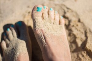 Sandy healthy feet with a fresh pedicure